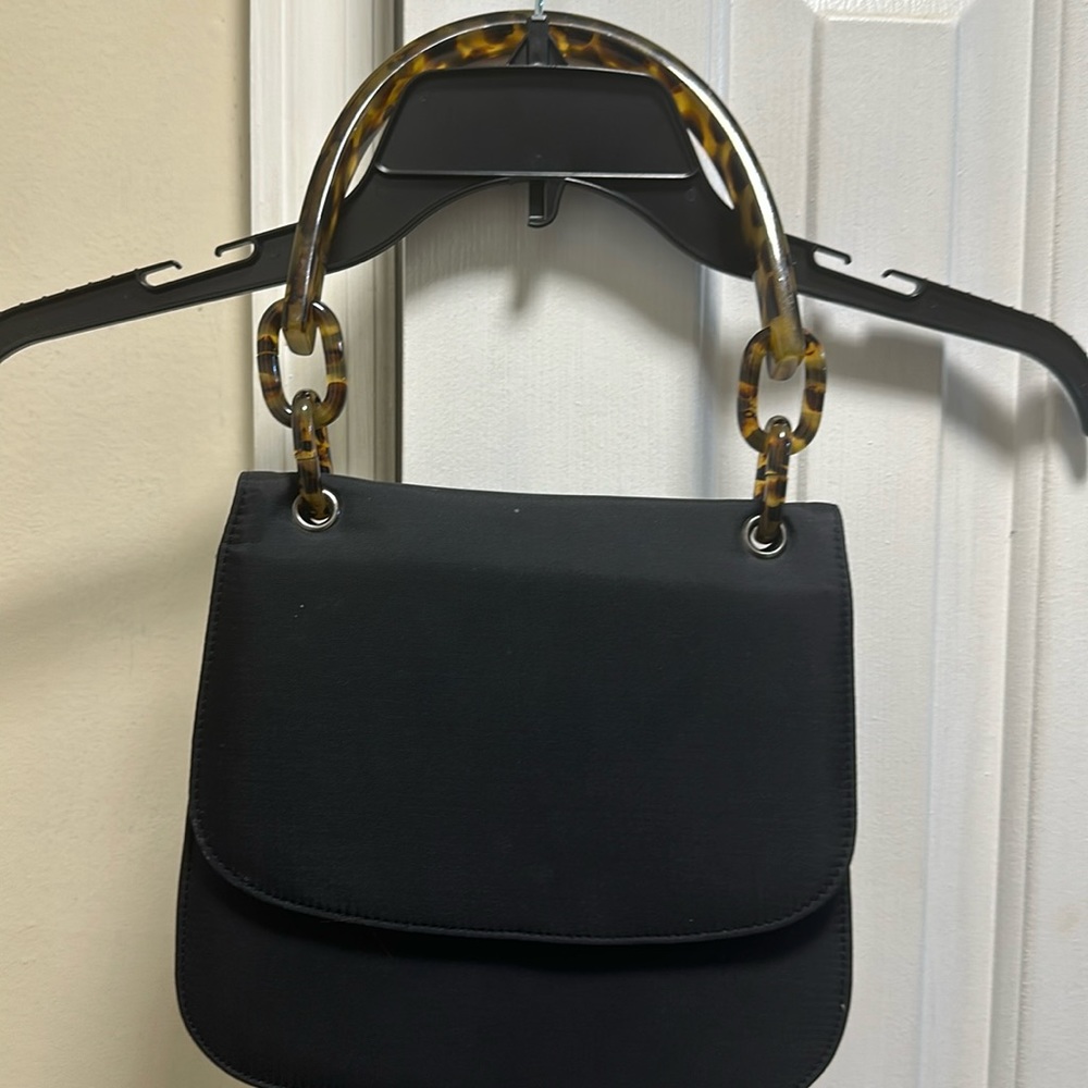 Sleek Black Handbag With A Turtle Shell Strap